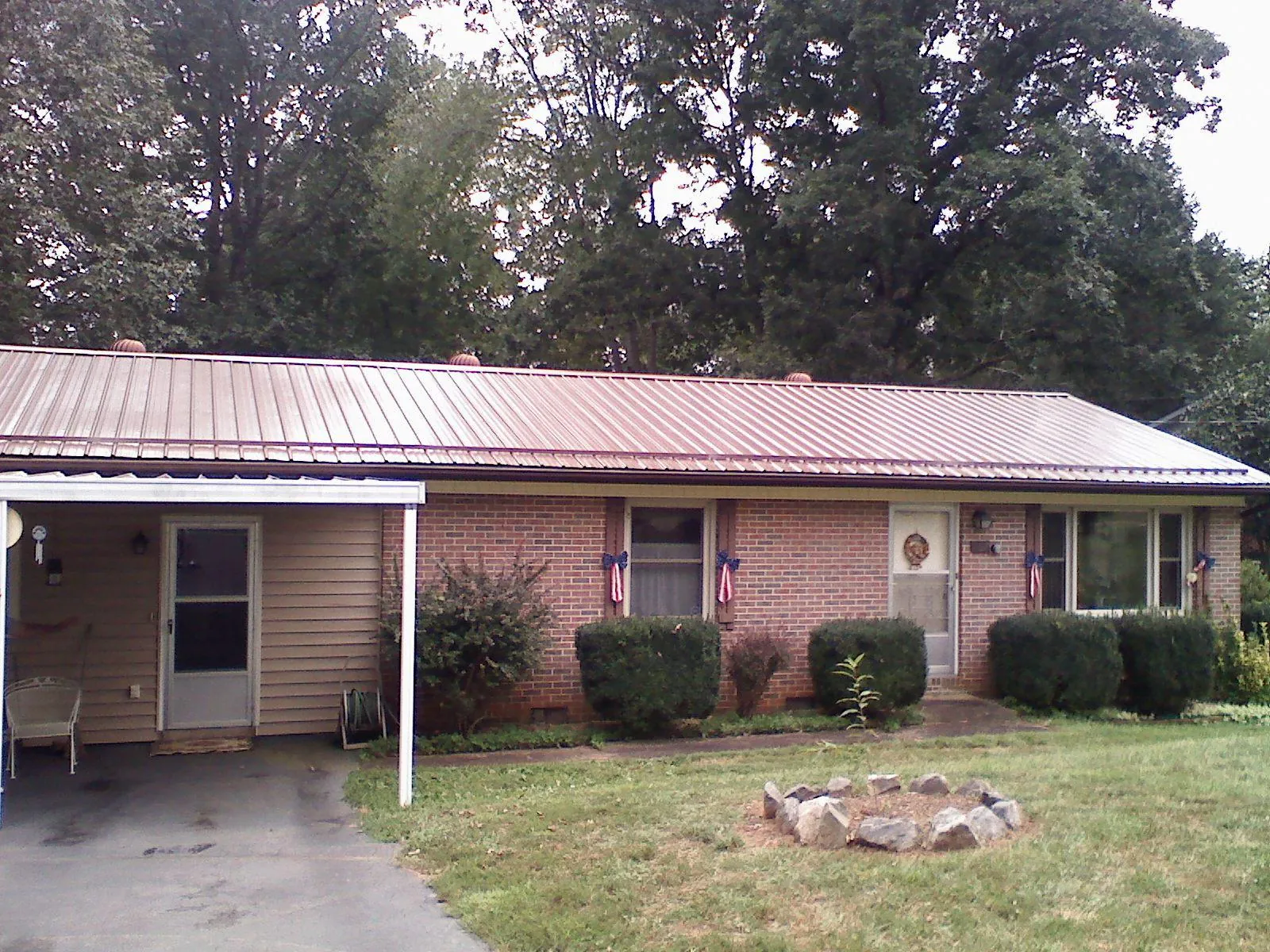Bronze metal roof and carport on a brick ranch home — Roof Repair work by our crew in Olin