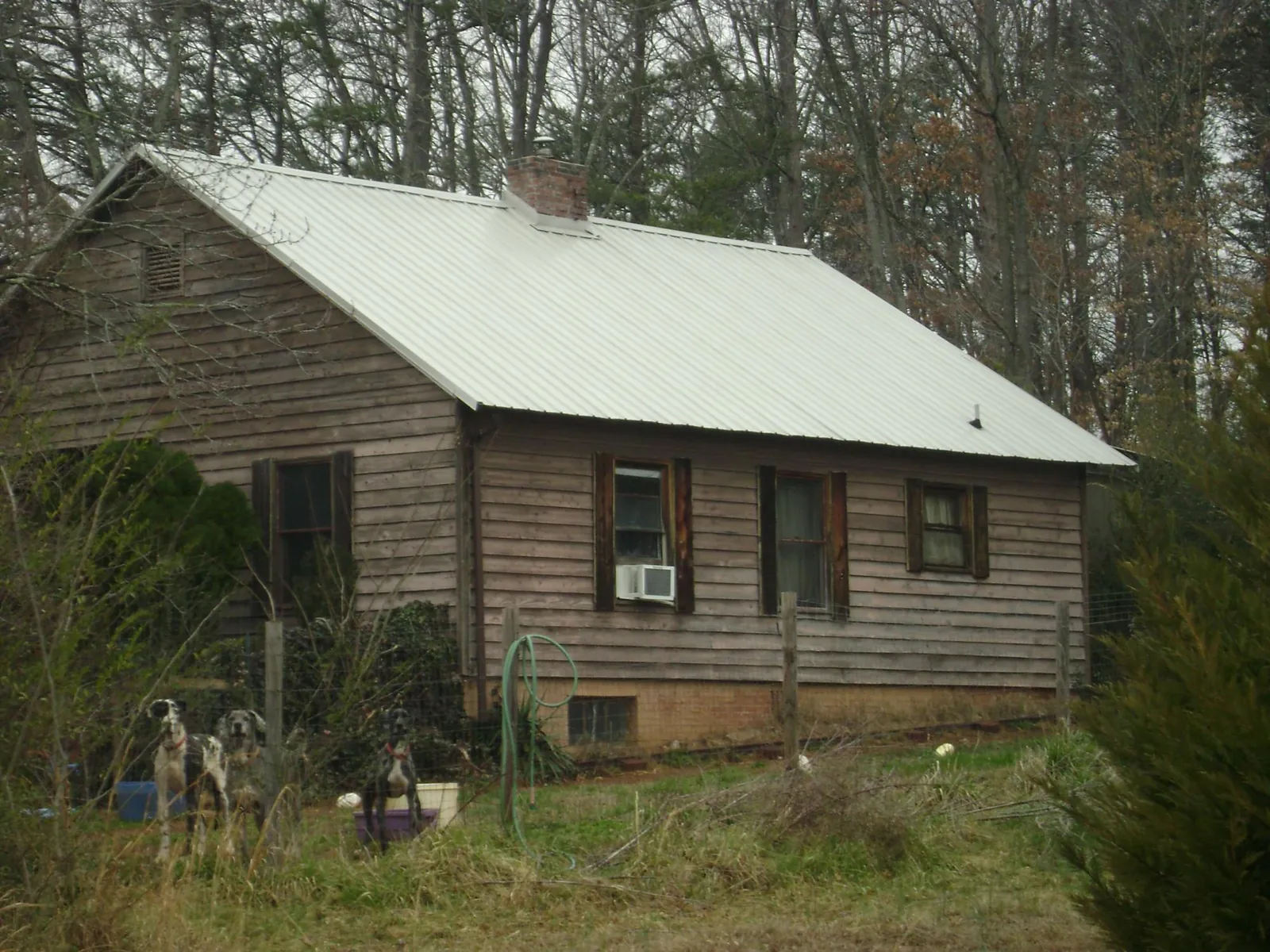 White metal roof on an old wood sided farmhouse, from a Metal Roof Installation job in Olin
